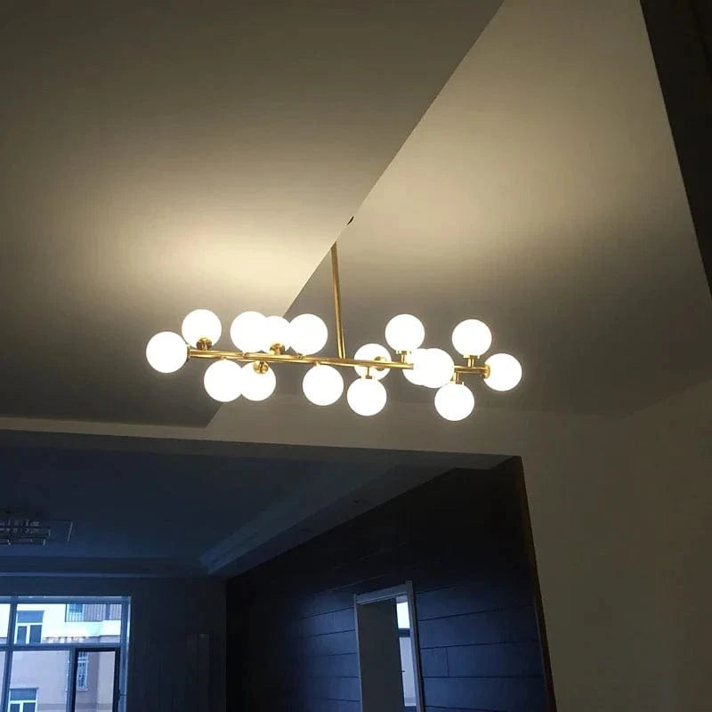 Lustre doré de luxe avec boule en verre et corps doré innovant | Marco Lucetti