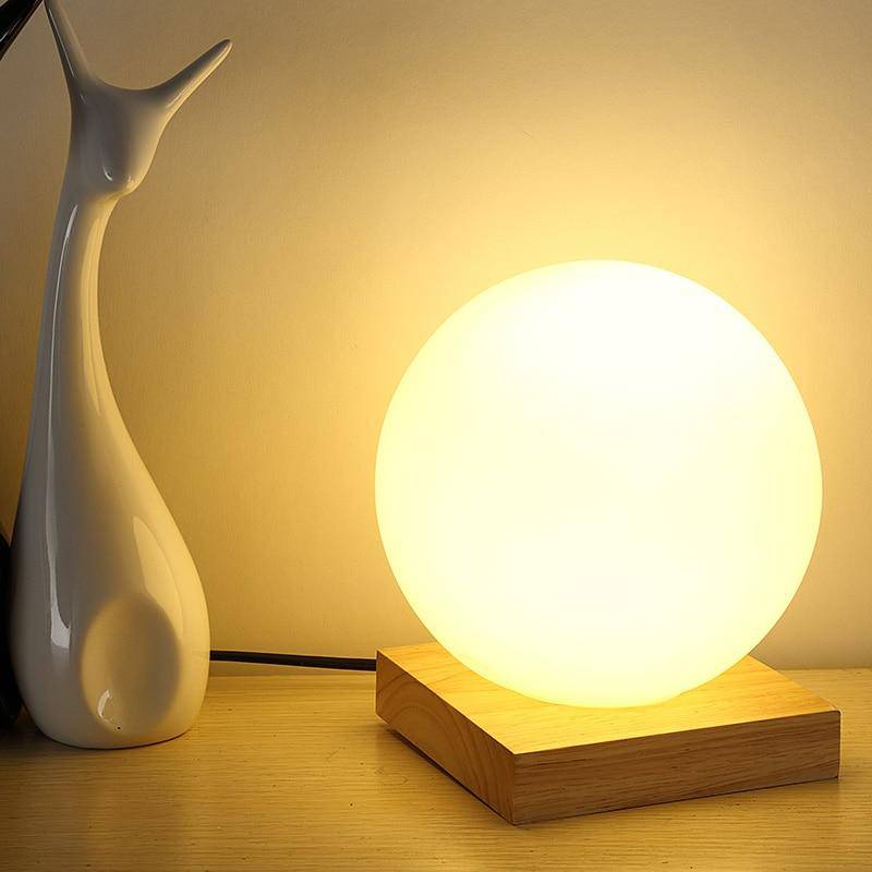 Lampe à poser LED design avec base en bois et boule en verre