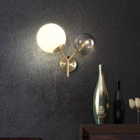 Applique murale LED dorée à deux boules en verre