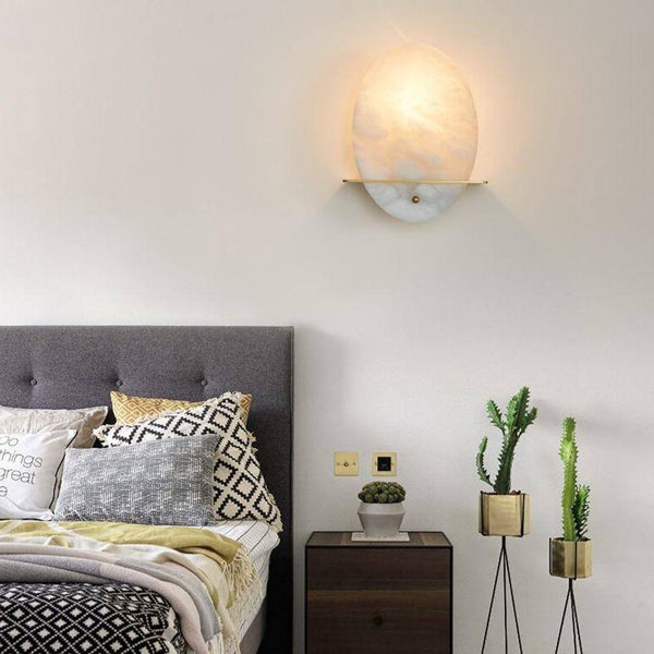 Applique murale LED ovale en marbre blanc et socle doré.