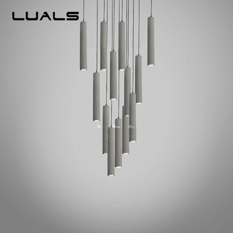 Suspension LED allongée en ciment gris.