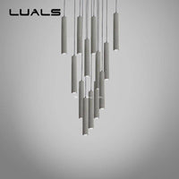 Suspension LED allongée en ciment gris.