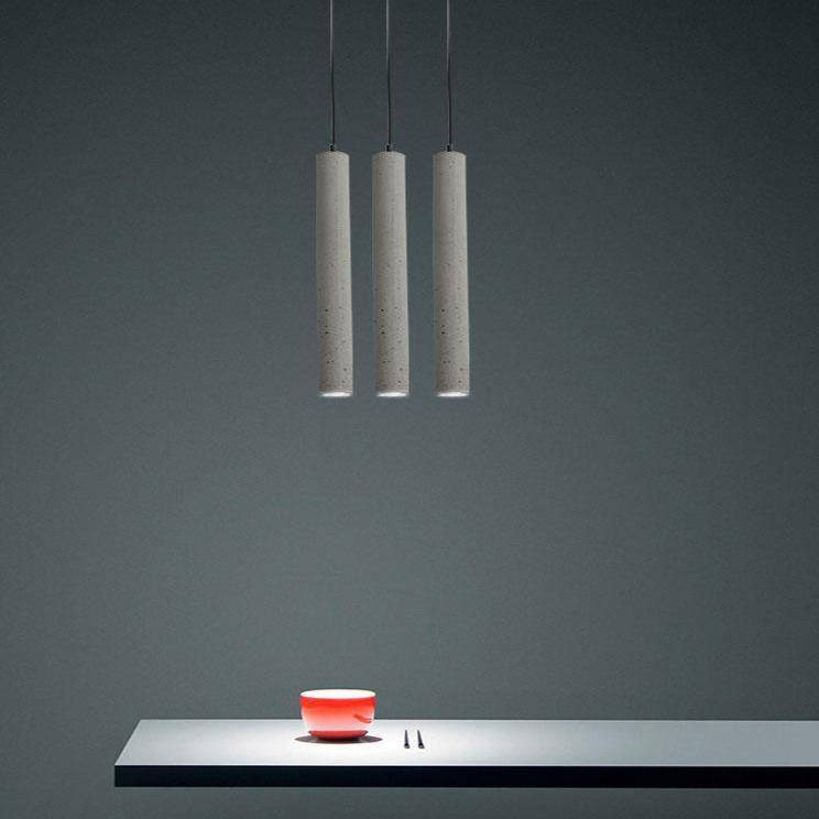 Suspension LED allongée en ciment gris.