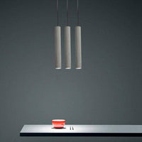 Suspension LED allongée en ciment gris.