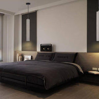 Suspension LED allongée en ciment gris.