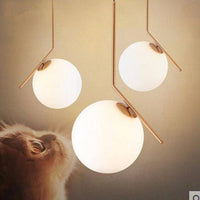 Suspension chic : barre dorée et boule en verre | Marco Lucetti